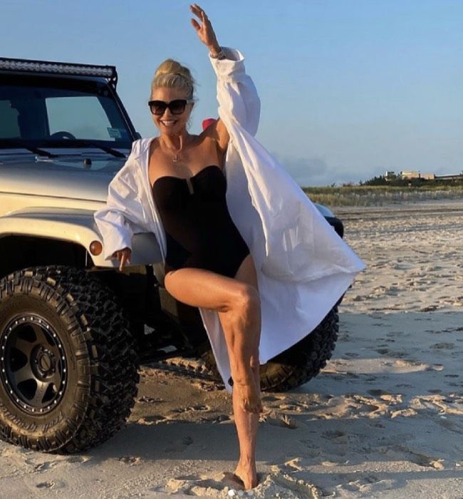 Christie Brinkley am Strand in einem schwarzen Badeanzug