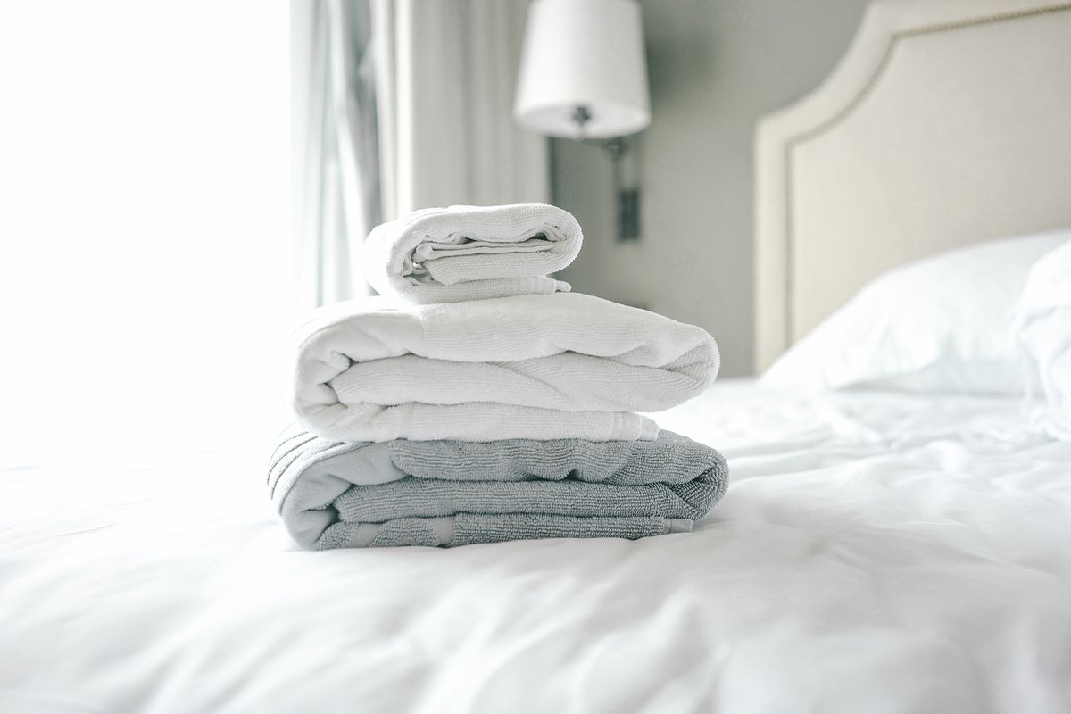 Stapel heller Handtücher auf dem Bett