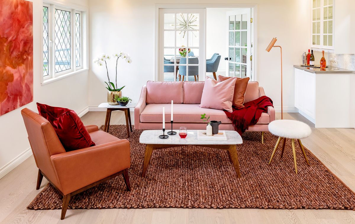 Wohnzimmer mit rosa Couch und strukturiertem Teppich