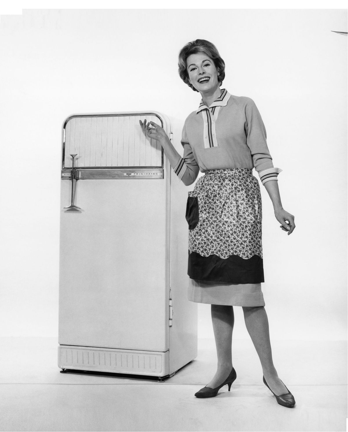 ženska pozira pred starinskim hladilnikom