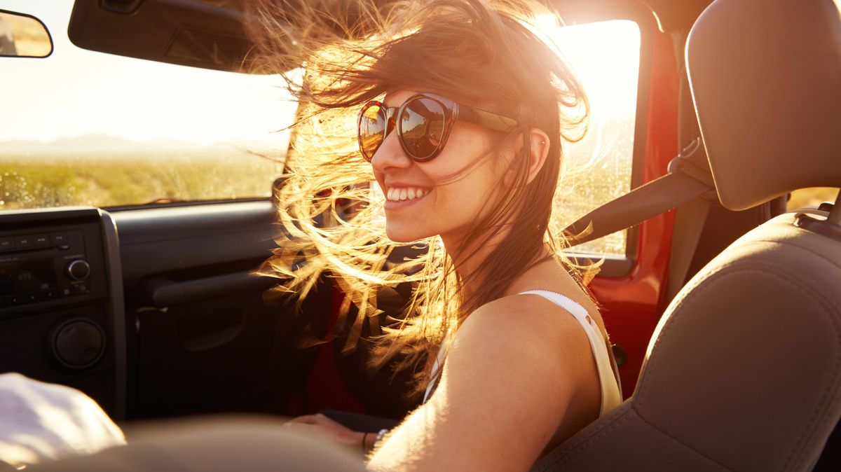 ženska v avtomobilu lase piha v vetru
