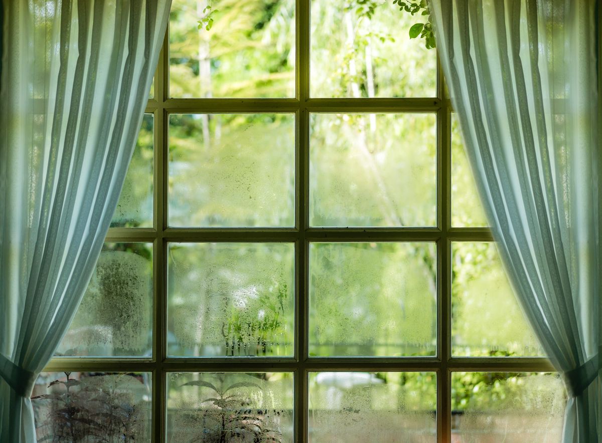 Stekleno okno s kondenzacijo in zavesami