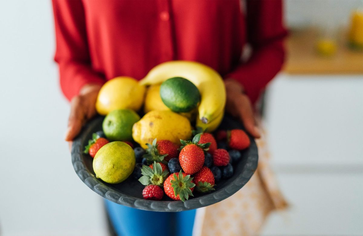 Frau hält Teller mit Früchten