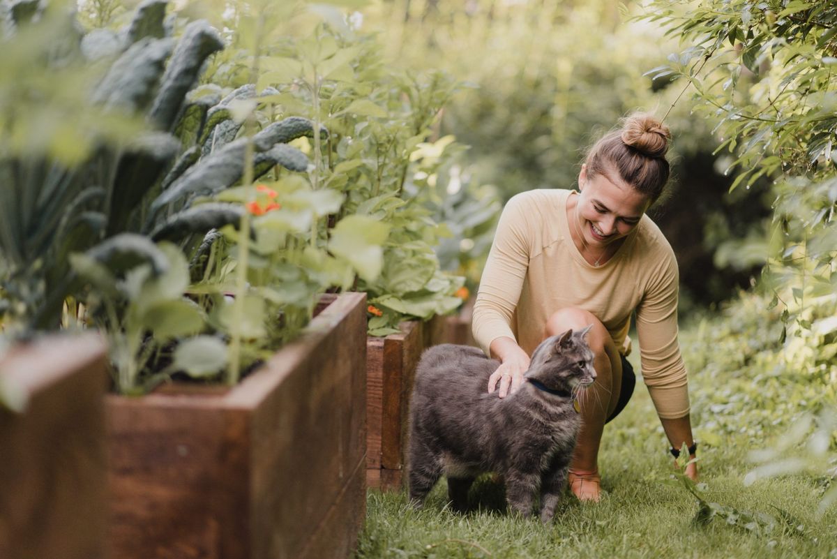 Vrtnarka z mačko na vrtu