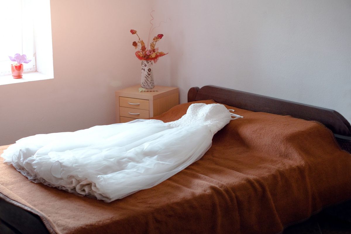 Hochzeitskleid auf dem Bett ausgestellt